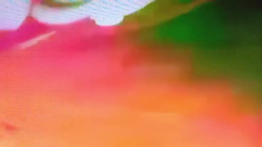 The video begins with abstract colorful imagery before transitioning to a scene featuring what appear to be stylized butterflies with green wings. Following this, a close-up shot shows a person wearing sunglasses. The next segment shows a blurred scene with multiple people, some appearing to be on a stage. The video concludes with a close-up of a blue, abstract form.