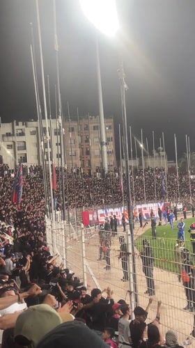 Packed stadium crowd cheers during nighttime event in Safi