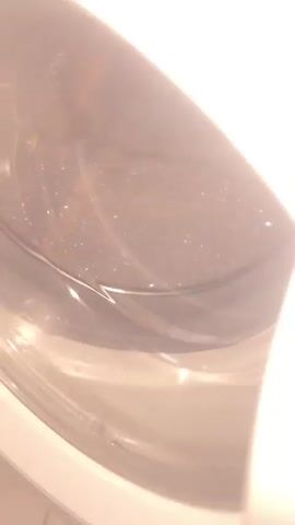 The video shows the inside of a washing machine drum. Initially, the door is open and the drum appears empty with some light reflections. Then the door is closed, and the drum fills with water and soap, creating a lot of foam. The camera moves around, showing the bubbling water and foam.