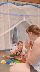 Mother and baby play inside tent in South Korea
