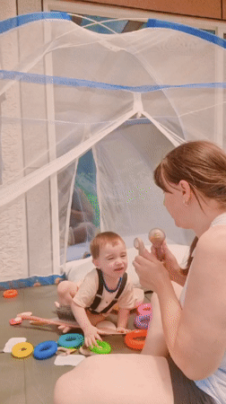 Mother and baby play inside tent in South Korea