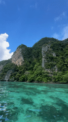 Speedboat threading limestone cliffs and turquoise water, Ao Nang