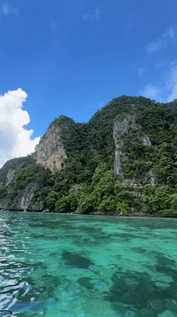 Speedboat threading limestone cliffs and turquoise water, Ao Nang