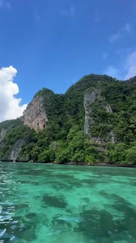 Speedboat threading limestone cliffs and turquoise water, Ao Nang