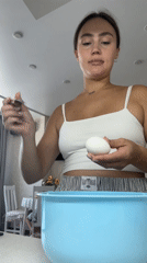 Woman cooks breakfast with baby present in Surgut kitchen