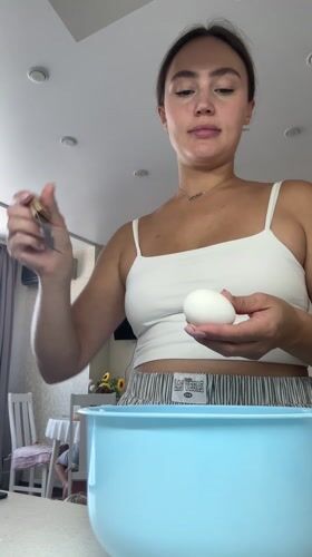 Woman cooks breakfast with baby present in Surgut kitchen
