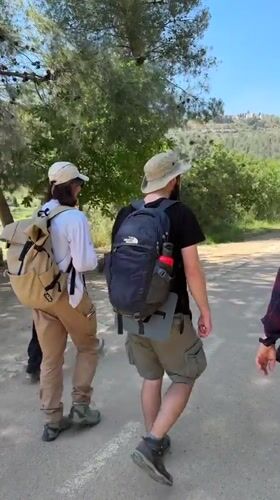 Hikers with dog walk rural Israel paths Friday morning
