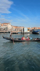 Gondola gliding through a Venice canal with passengers aboard.