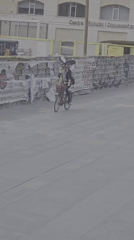 Costumed cyclist with fan headdress performs through Barcelona streets