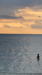 Beachgoers enjoy sunset with colorful beanbags at Indonesian coast