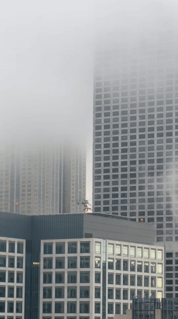 Fog blankets Chicago skyline as helicopter lands downtown
