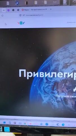 The video shows a computer monitor displaying a website. The website has a dark background with an image of Earth. The text on the screen is in Russian and translates to "Privileged Early Access" and "Get your registration today as a gift!". The website's logo, "Success Together," is visible. The computer's operating system is visible at the top of the screen, with a browser tab indicating the website's URL as "www.success.su/igor1". The lower part of the monitor shows the brand name "AOC". The video is shot from a slightly elevated angle.