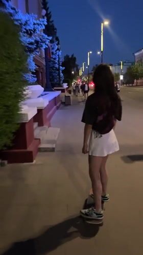 Woman skateboards, dines in Krasnoyarsk during evening hours