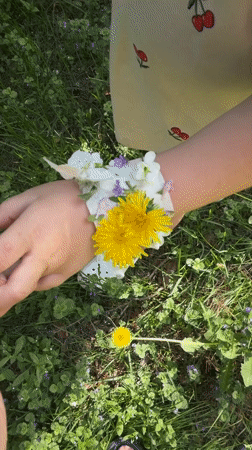 Child and adult craft flower bracelets outdoors in Russia