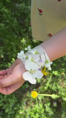 Child and adult craft flower bracelets outdoors in Russia