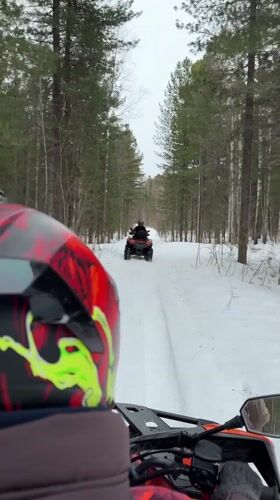 ATV rider navigates snowy forest path near Izluchinsk