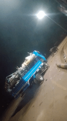 Blue pickup truck overturns with heavy cargo load