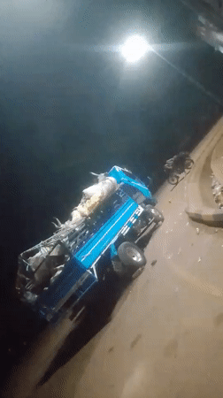 Blue pickup truck overturns with heavy cargo load