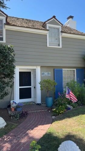 Gray two-story house with open front door, Long Beach