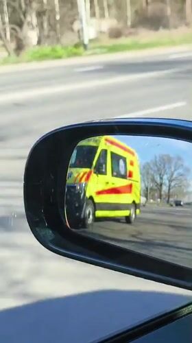 Emergency ambulance passes vehicle in morning Riga traffic