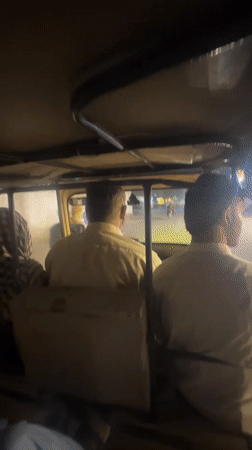Two men ride auto-rickshaw through Quetta at night