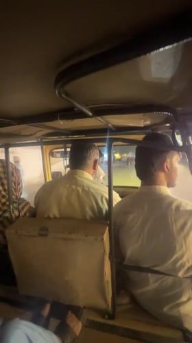 Two men ride auto-rickshaw through Quetta at night