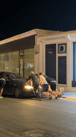 Evening street activities in Paphos: car push, scooter tricks