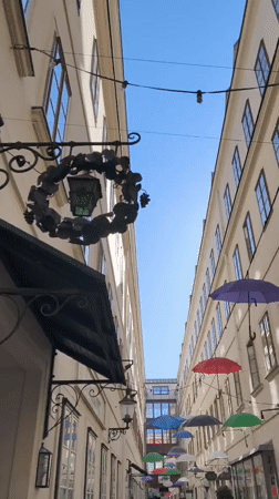 Vienna alleyway covered in a canopy of colorful suspended umbrellas