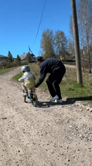 Child learns bicycle riding with adult assistance in Rezekne