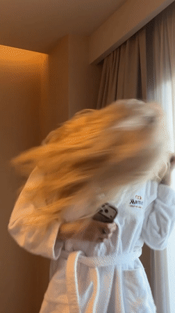 Woman dances with phone in Turkish hotel room