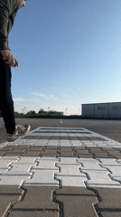 Street performer does handstand near modern buildings in Burgas