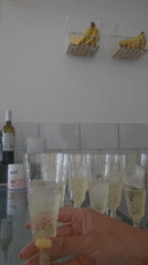 Person mixes juice cocktail in champagne glass in Puebla