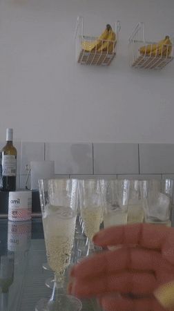 Person mixes juice cocktail in champagne glass in Puebla