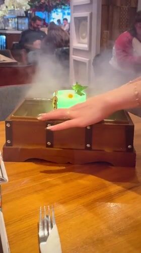 London bartender serves theatrical green cocktail with smoking presentation