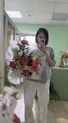 Woman takes flower bouquet selfies in Izhevsk mirror