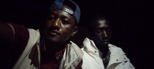 Young men gather outdoors at night in Jos, Nigeria