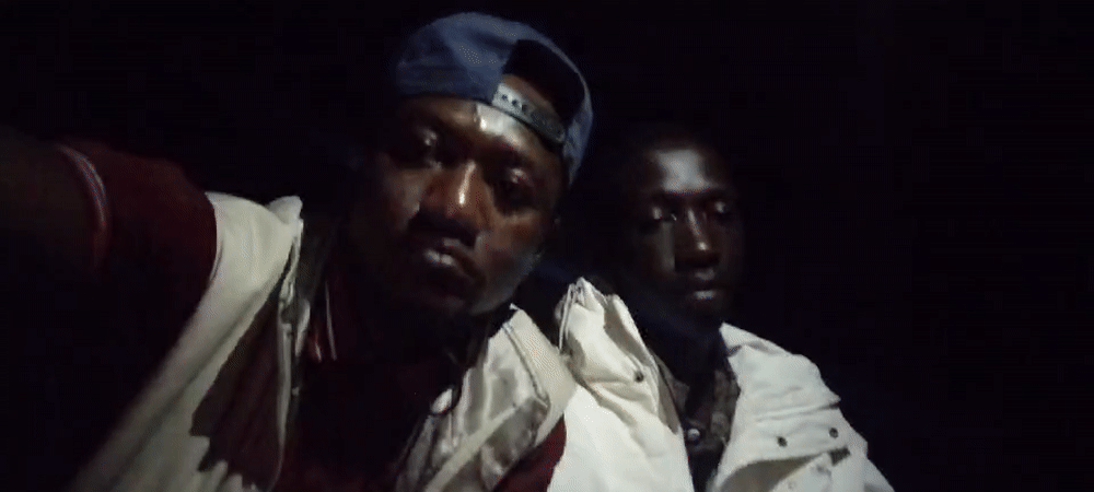 Young men gather outdoors at night in Jos, Nigeria