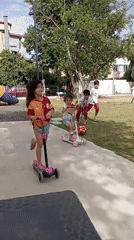 Children play soccer, scooters at sunny park playground
