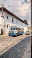Decorated vintage bus on cobblestones, stone ruins glowing at dusk