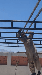 Construction worker welds metal beams on Quetta rooftop