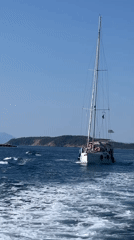 Sailing past a rocky Greek island under clear skies