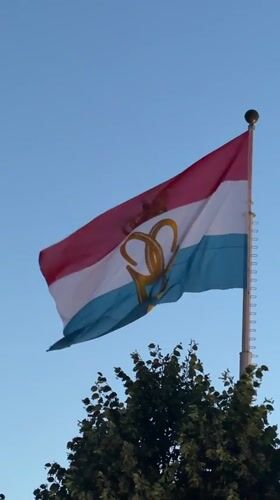 A summer evening in Luxembourg City with flags and outdoor drinks