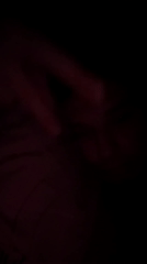 Person observed resting with hand covering face in low-light