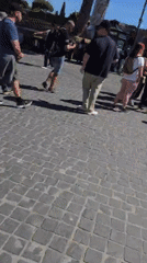 Morning street life in Rome: tourists, costumed performers, violin player