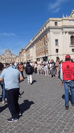 Morning street life in Rome: tourists, costumed performers, violin player