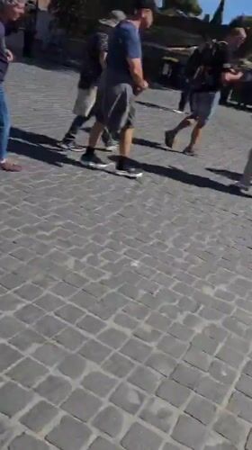 Morning street life in Rome: tourists, costumed performers, violin player