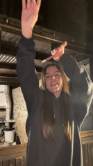 Arms raised, dancing with a pink object in Kerenite