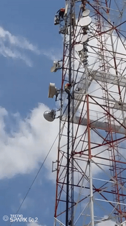 Telecom workers install equipment on tower in Tinaquillo, Venezuela