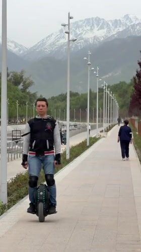 Unicyclist and duck share waterway path in Almaty