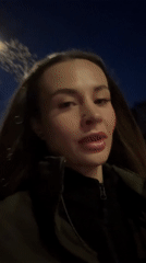 Woman walks through illuminated Kyiv streets at night
